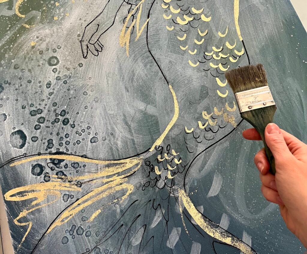 working on mermaids with gold leaf